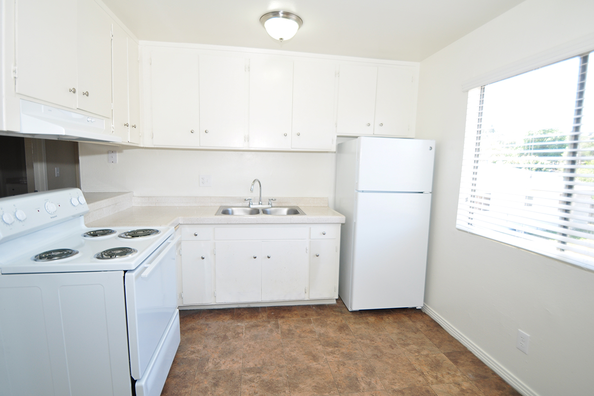 a white stove top oven sitting inside of a kitchen