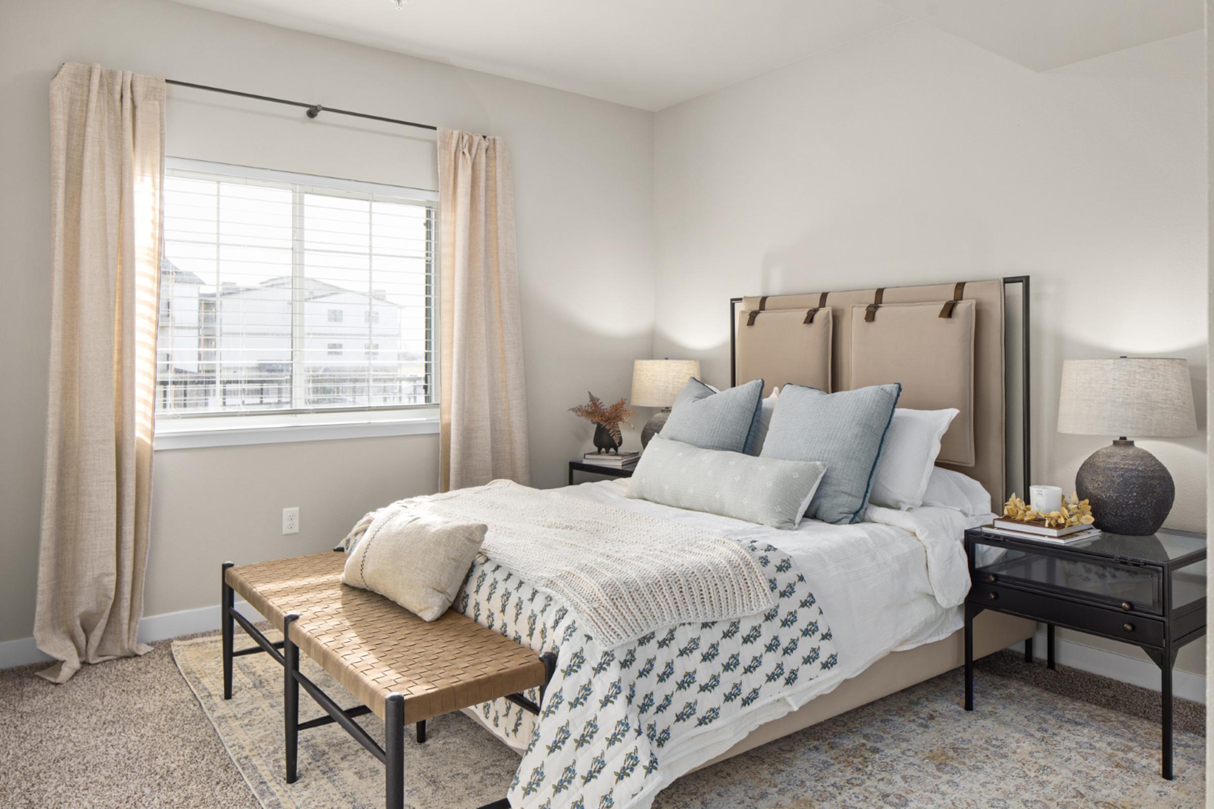 a bedroom with a bed and desk in a hotel room