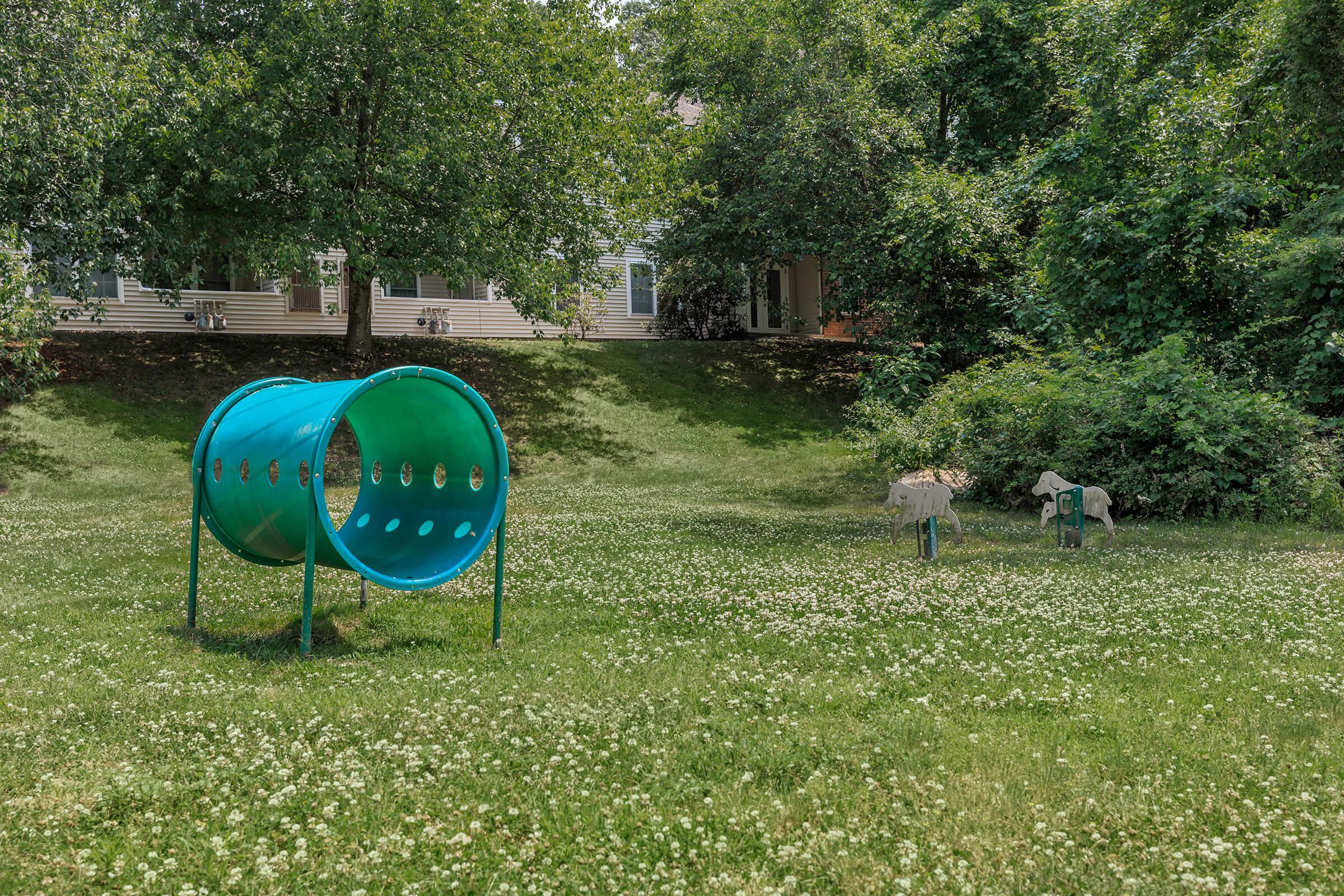 a couple of lawn chairs sitting on top of a grass covered field