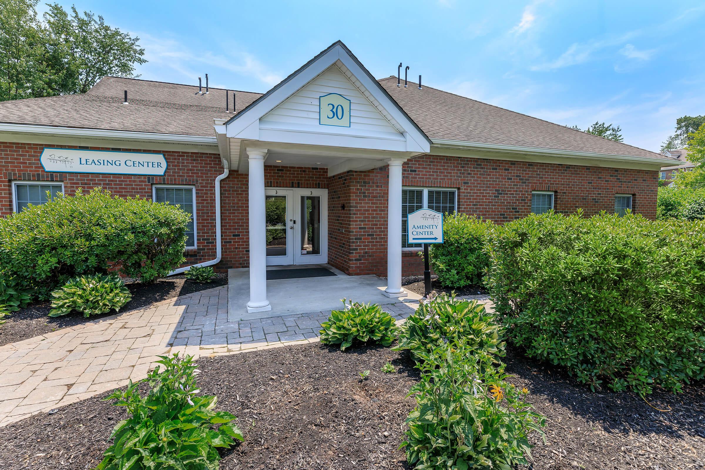 a house with bushes in front of a brick building