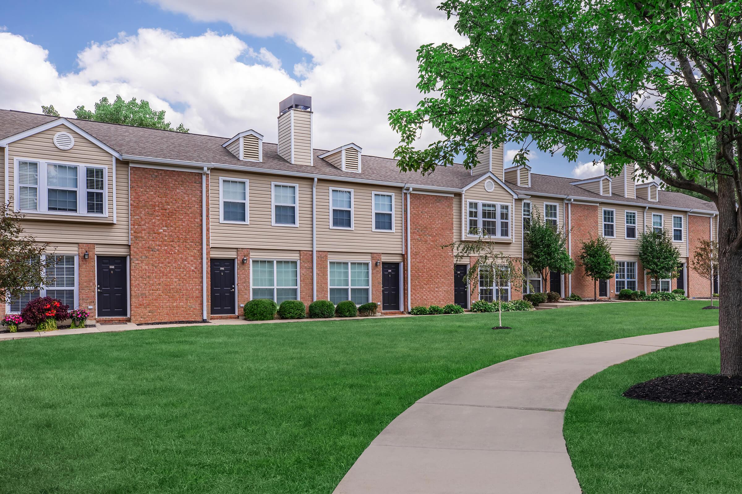 a large lawn in front of a brick building