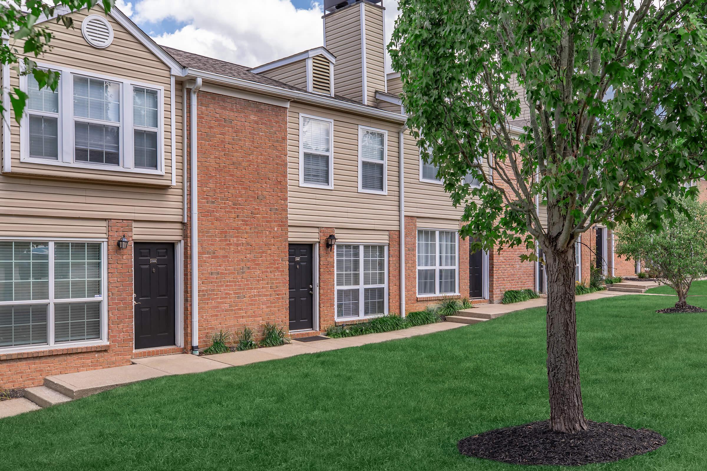 a large lawn in front of a brick building