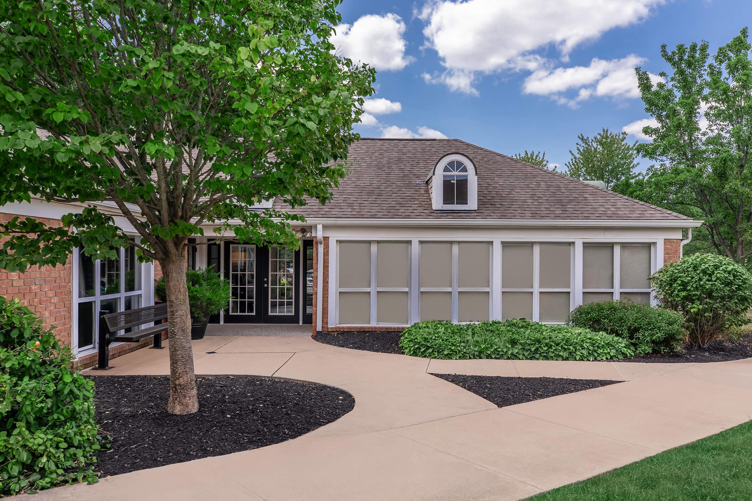 a house with bushes in front of a brick building