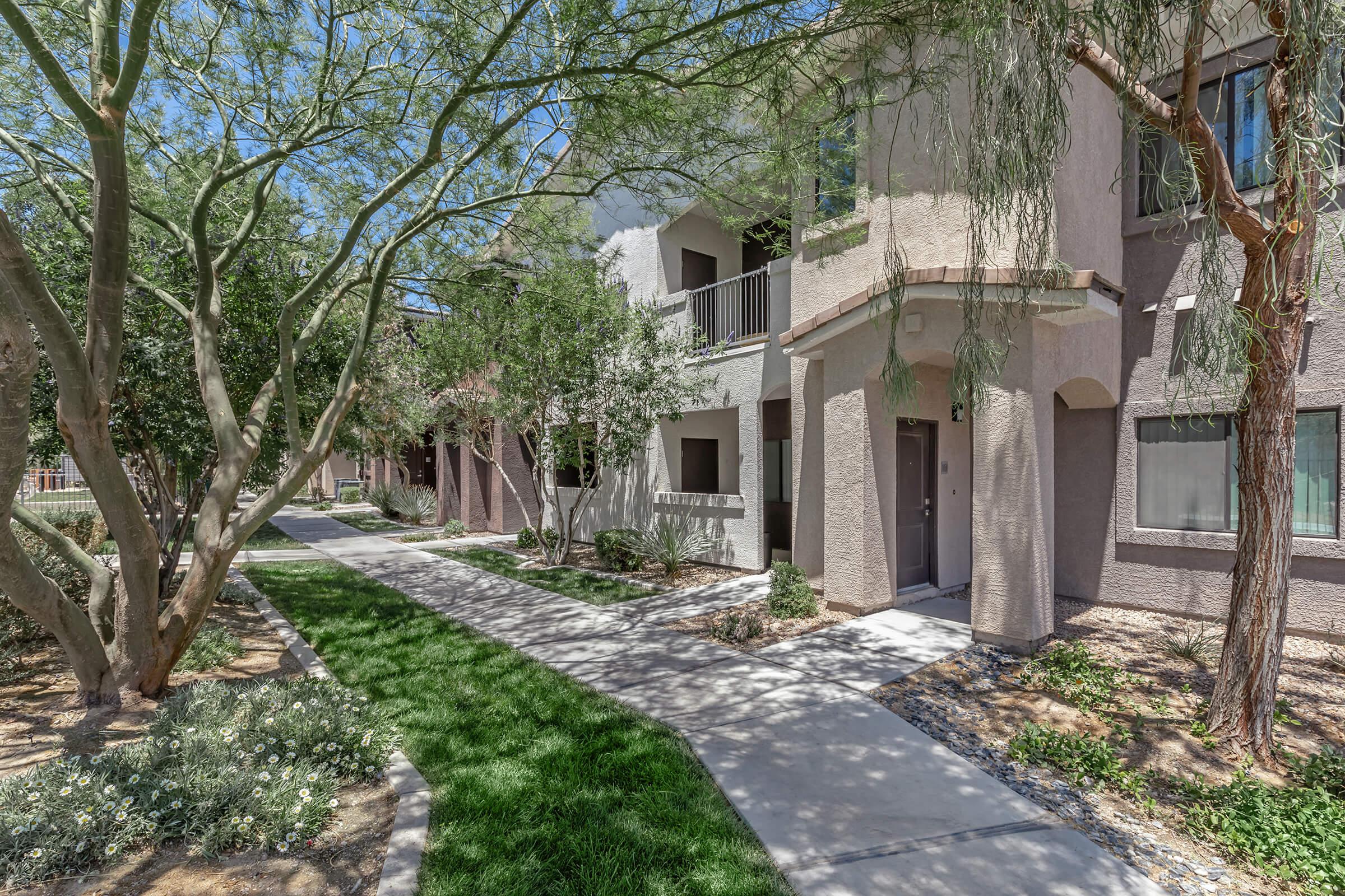 a path with trees on the side of a building