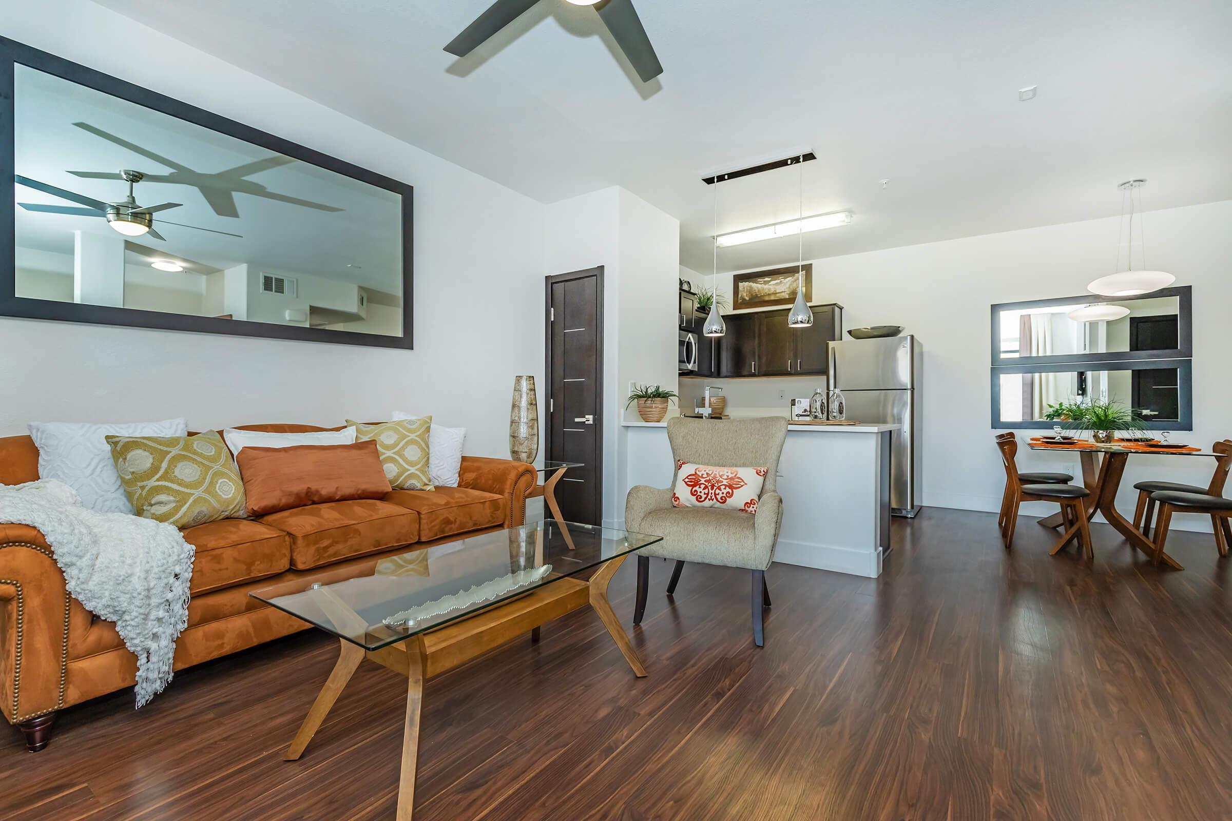 a living room filled with furniture on top of a hard wood floor