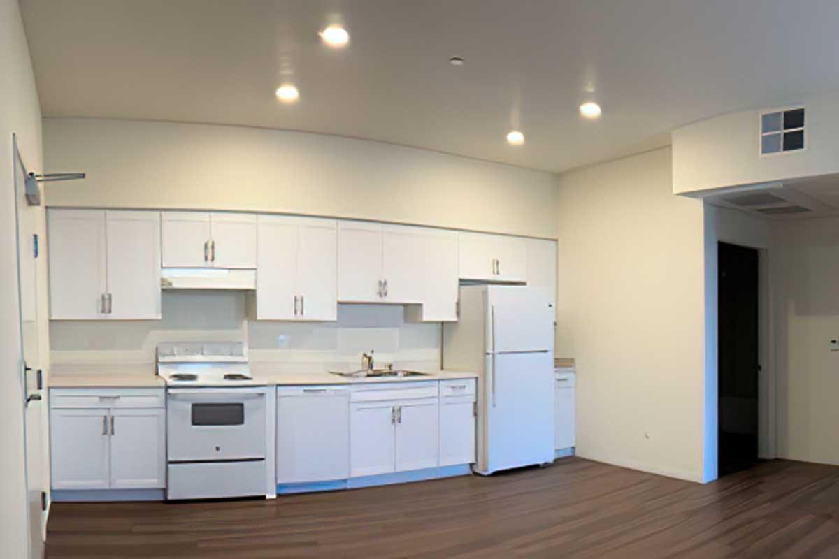 Modern kitchen featuring sleek white cabinetry, a white refrigerator, a stove, and a sink.