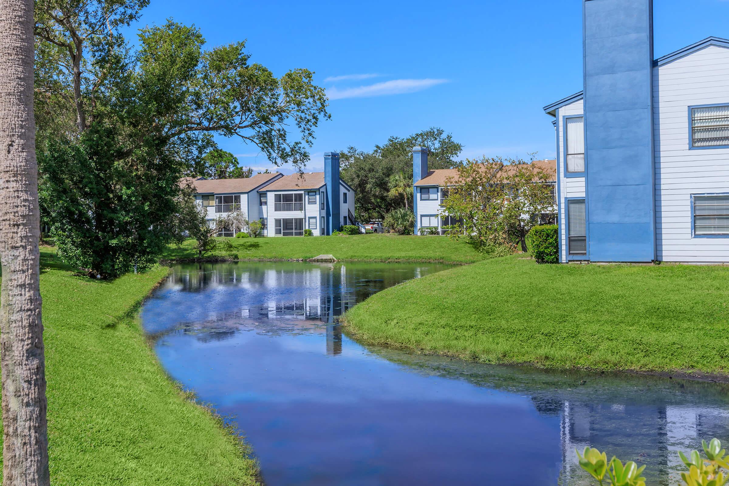 a house with a lawn in front of a body of water