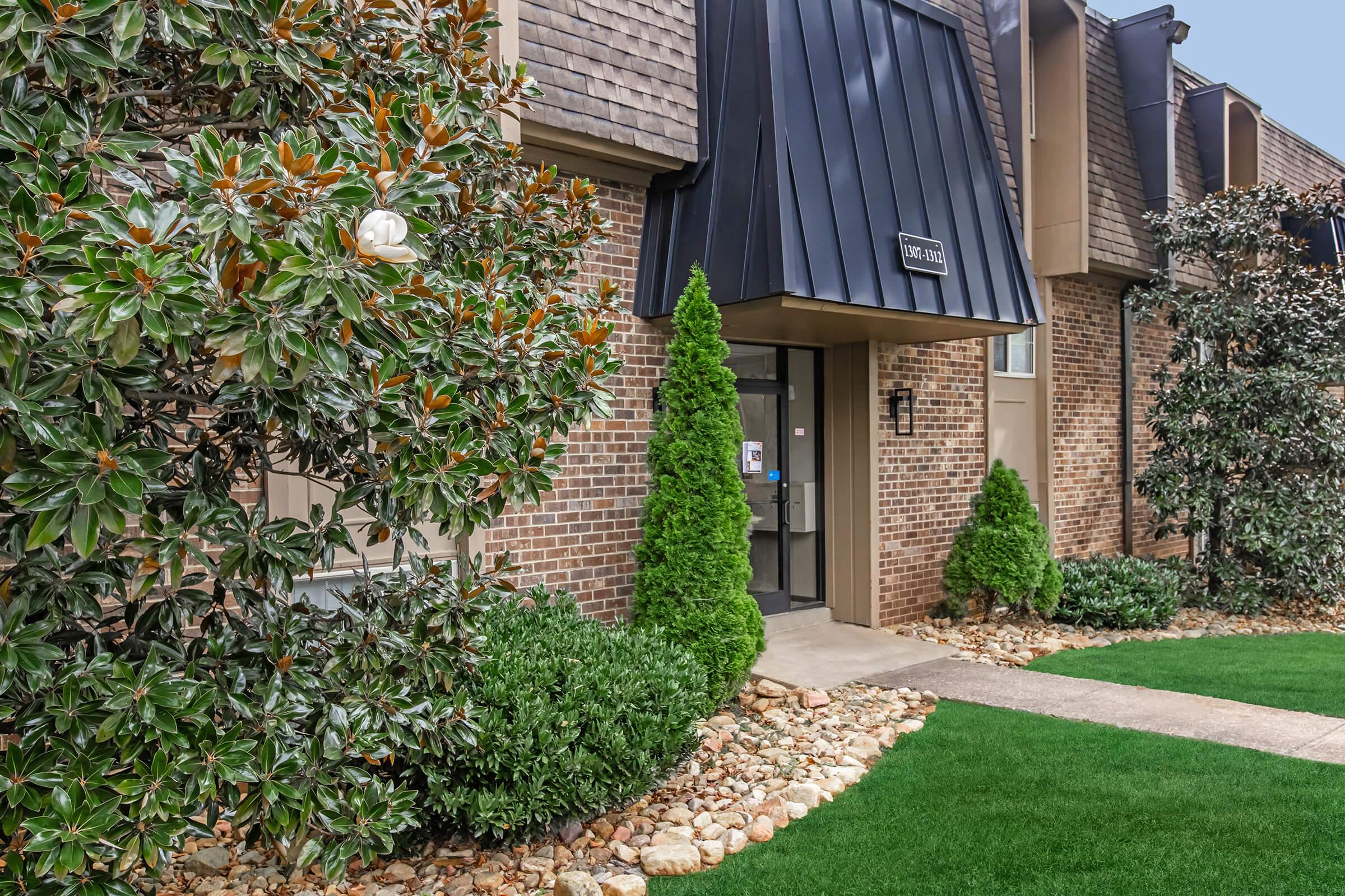 a garden in front of a brick building