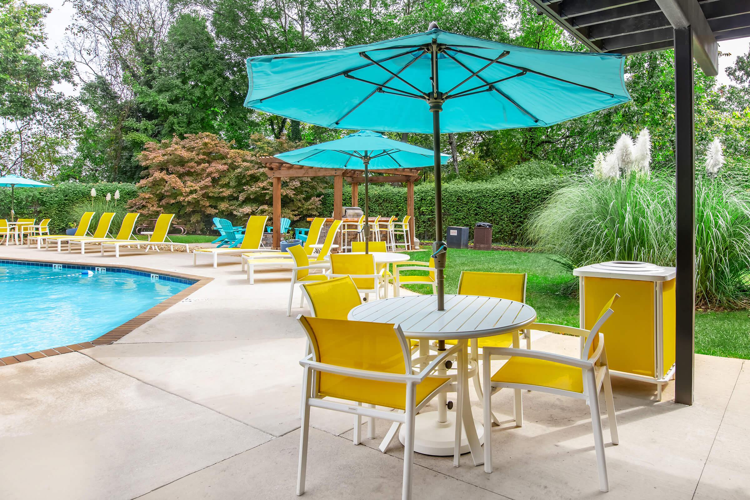 a group of lawn chairs sitting next to a pool of water