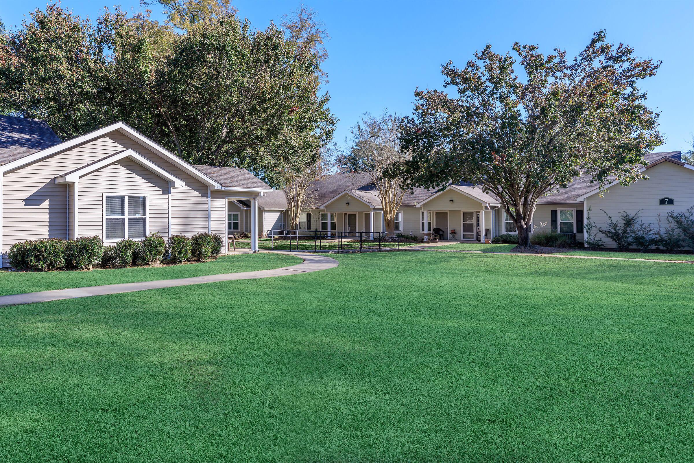 a large green field in front of a house