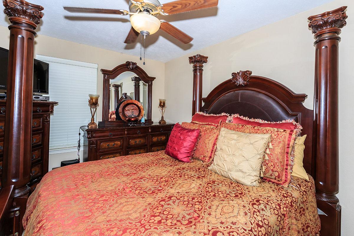 a bedroom with a large red chair in a room