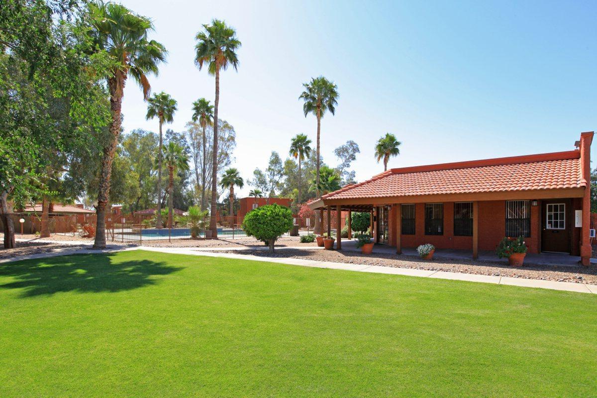 a large brick building with green grass