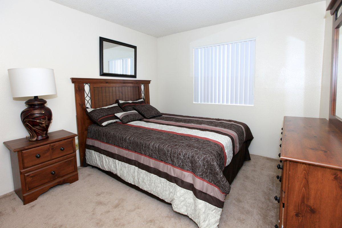 a bedroom with a bed and desk in a hotel room