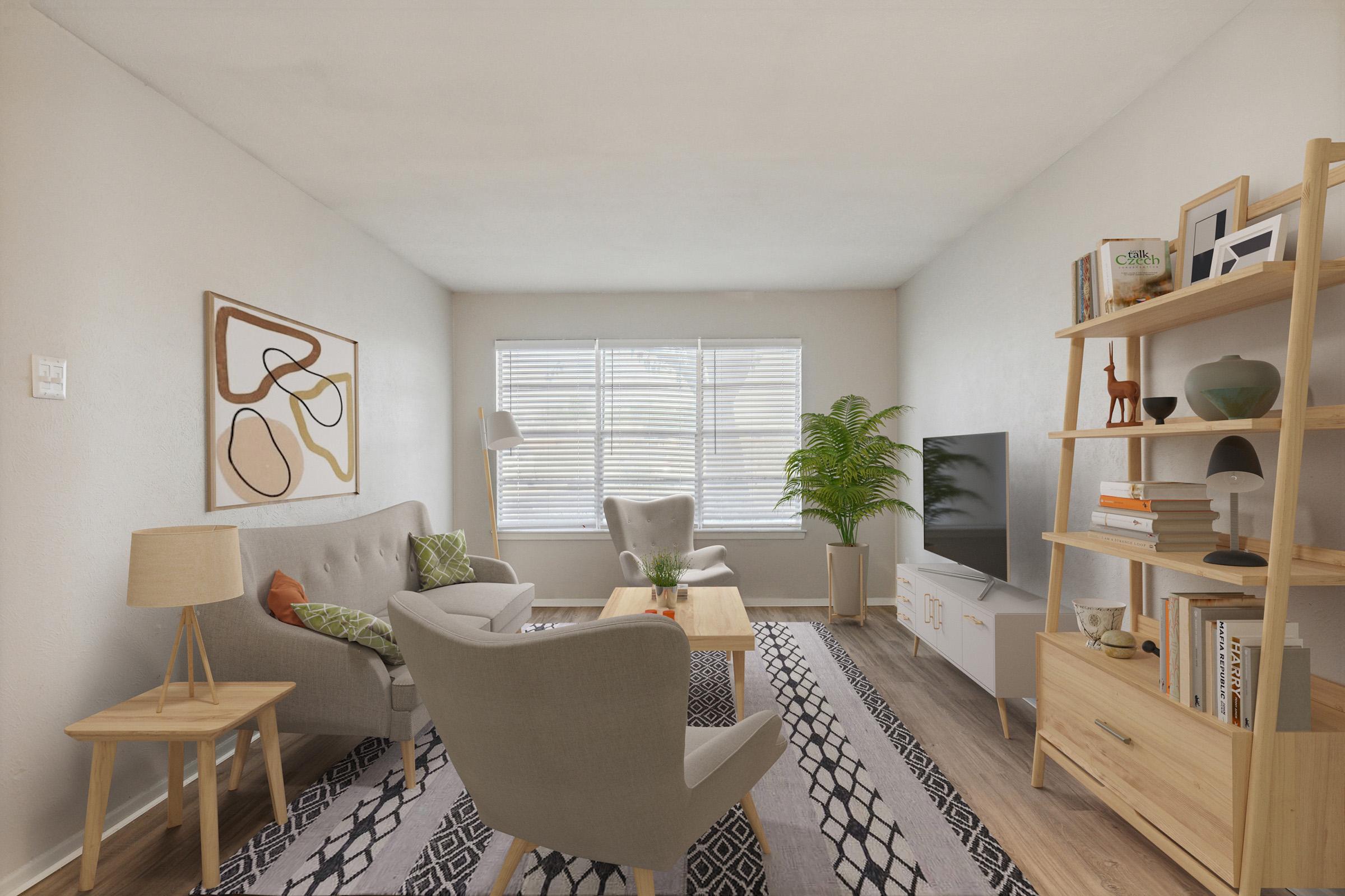 A cozy living room featuring a light color scheme, two armchairs, a wooden coffee table, and a bookshelf decorated with plants and books. There's a large window with white blinds allowing natural light in, and a TV on a white cabinet against the wall. A modern abstract artwork hangs on the wall.