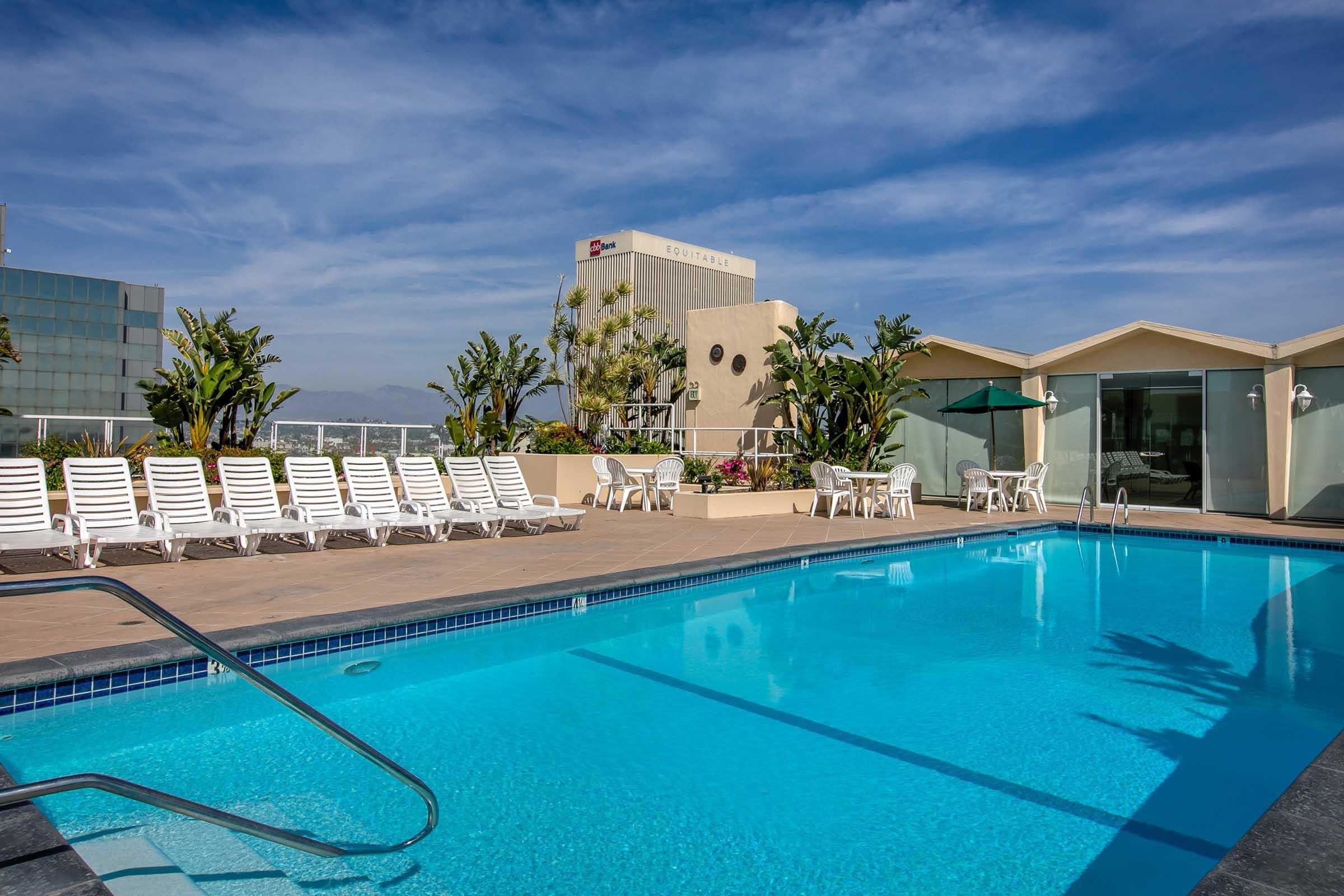 a pool next to chairs and a building