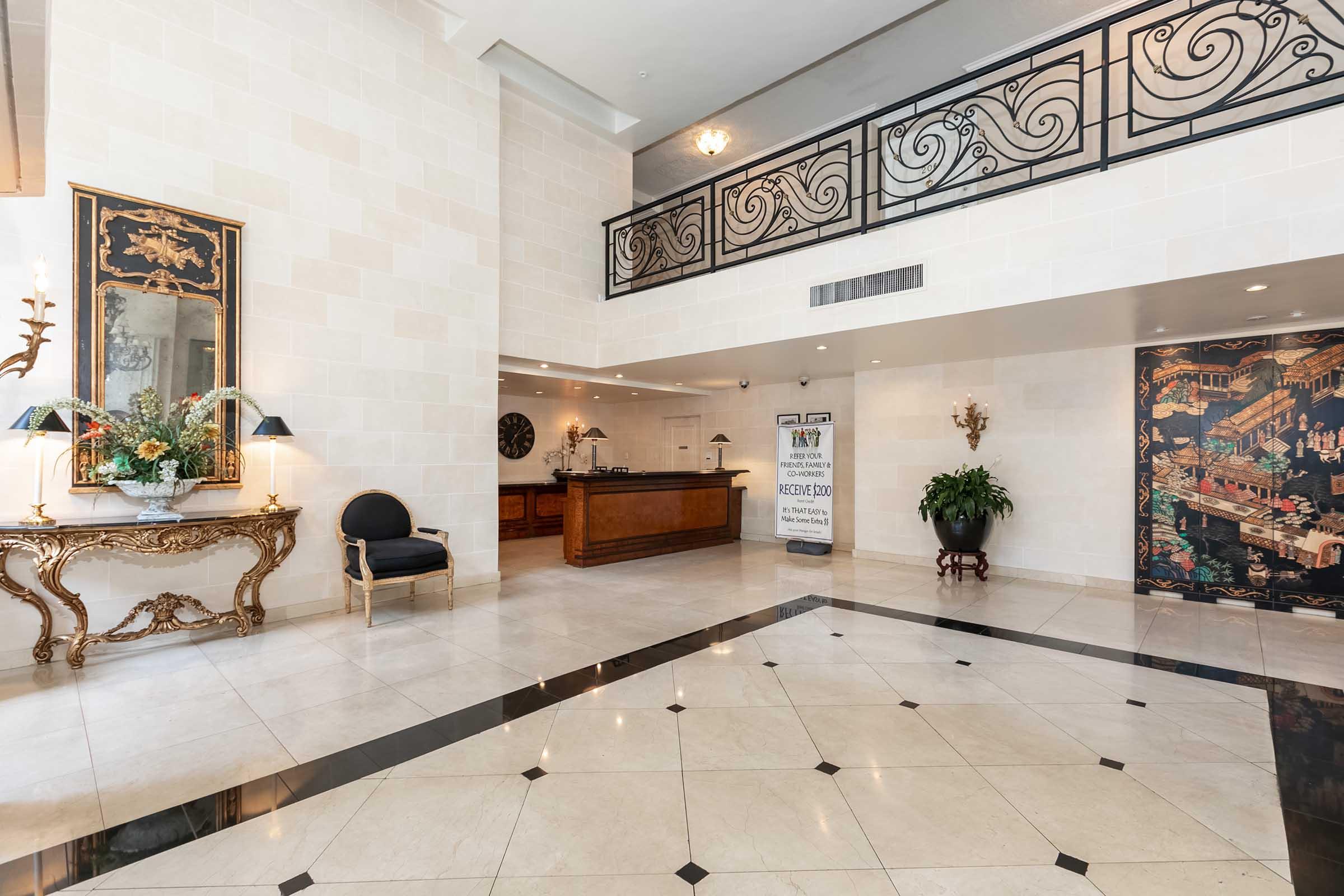 a lobby with a desk and railing in the background