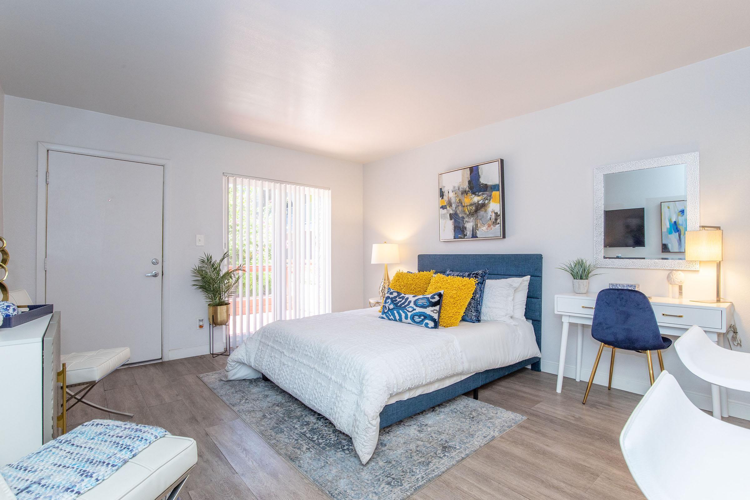 a bedroom with a bed and desk in a room