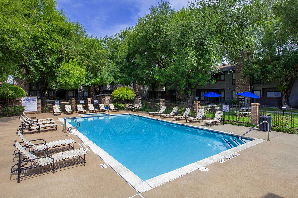 a group of lawn chairs sitting next to a pool of water