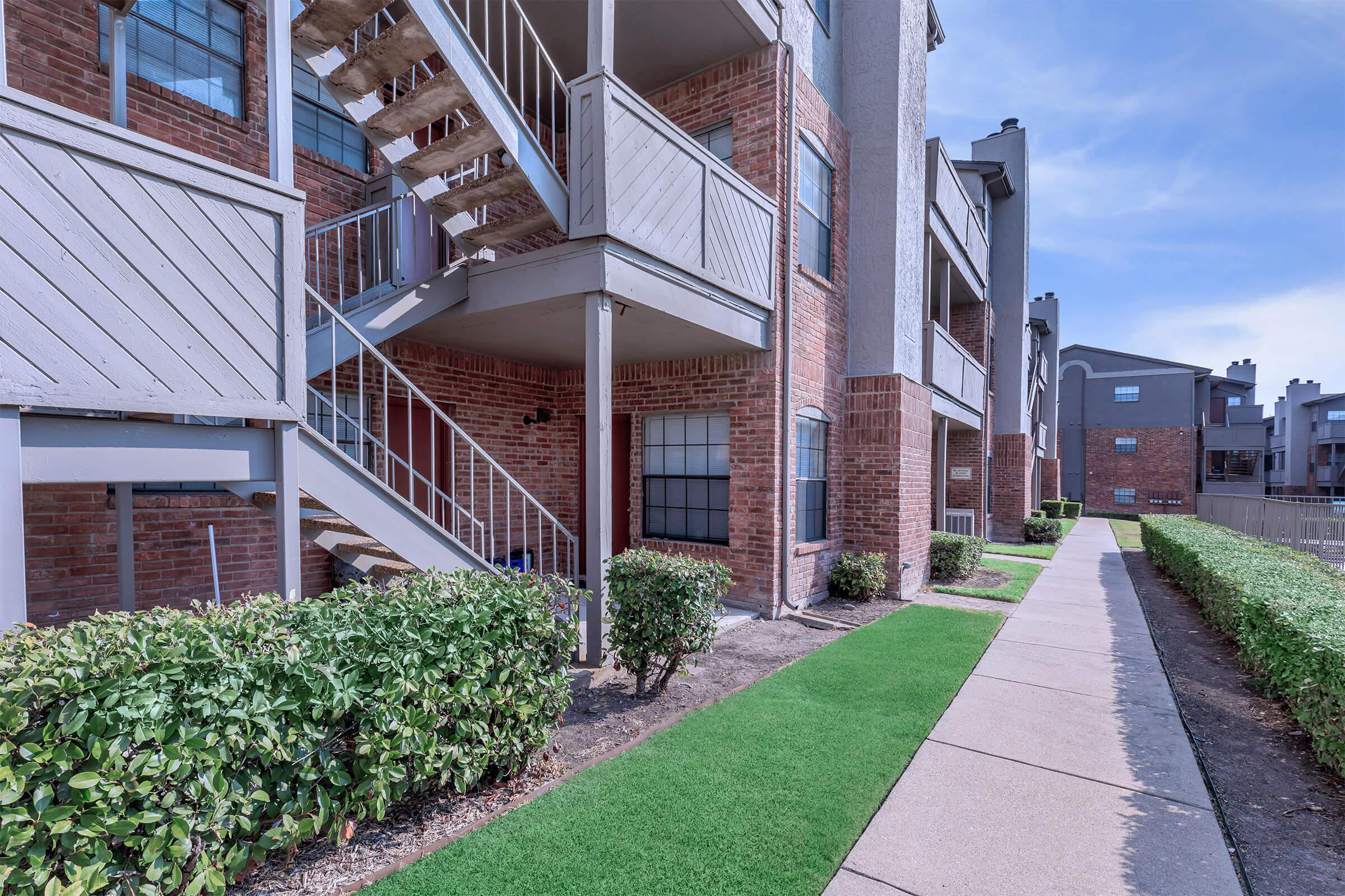 a path leading to a brick building