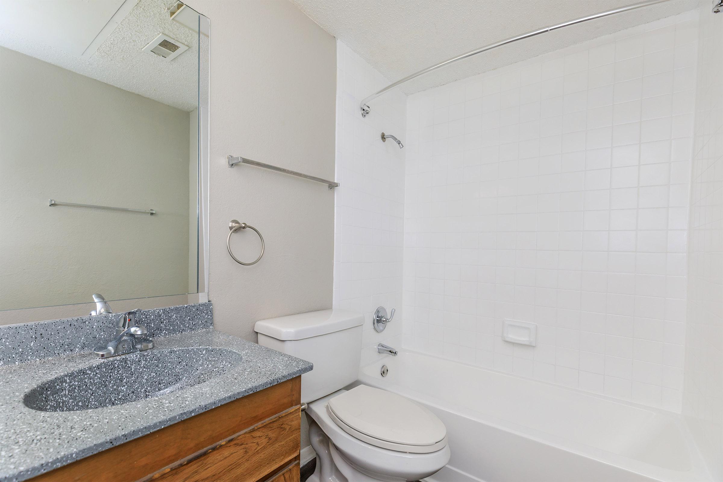 a white sink sitting under a mirror