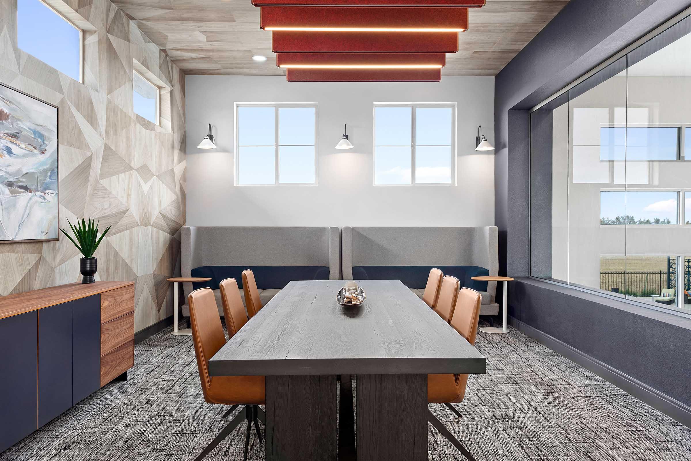 Modern conference room featuring a long table with eight leather chairs, a textured wall with geometric patterns, large windows letting in natural light, and decor including a plant and artwork. The space is designed for collaboration and meetings, with a stylish, contemporary aesthetic.