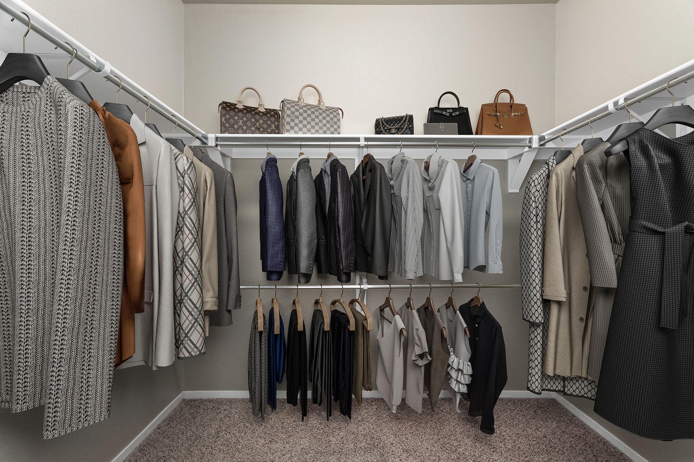 A neatly organized closet featuring a variety of hanging clothing, including coats, blazers, and dresses in neutral tones. Several handbags are displayed on shelves above, adding a stylish touch to the space. The overall aesthetic is clean and well-coordinated.