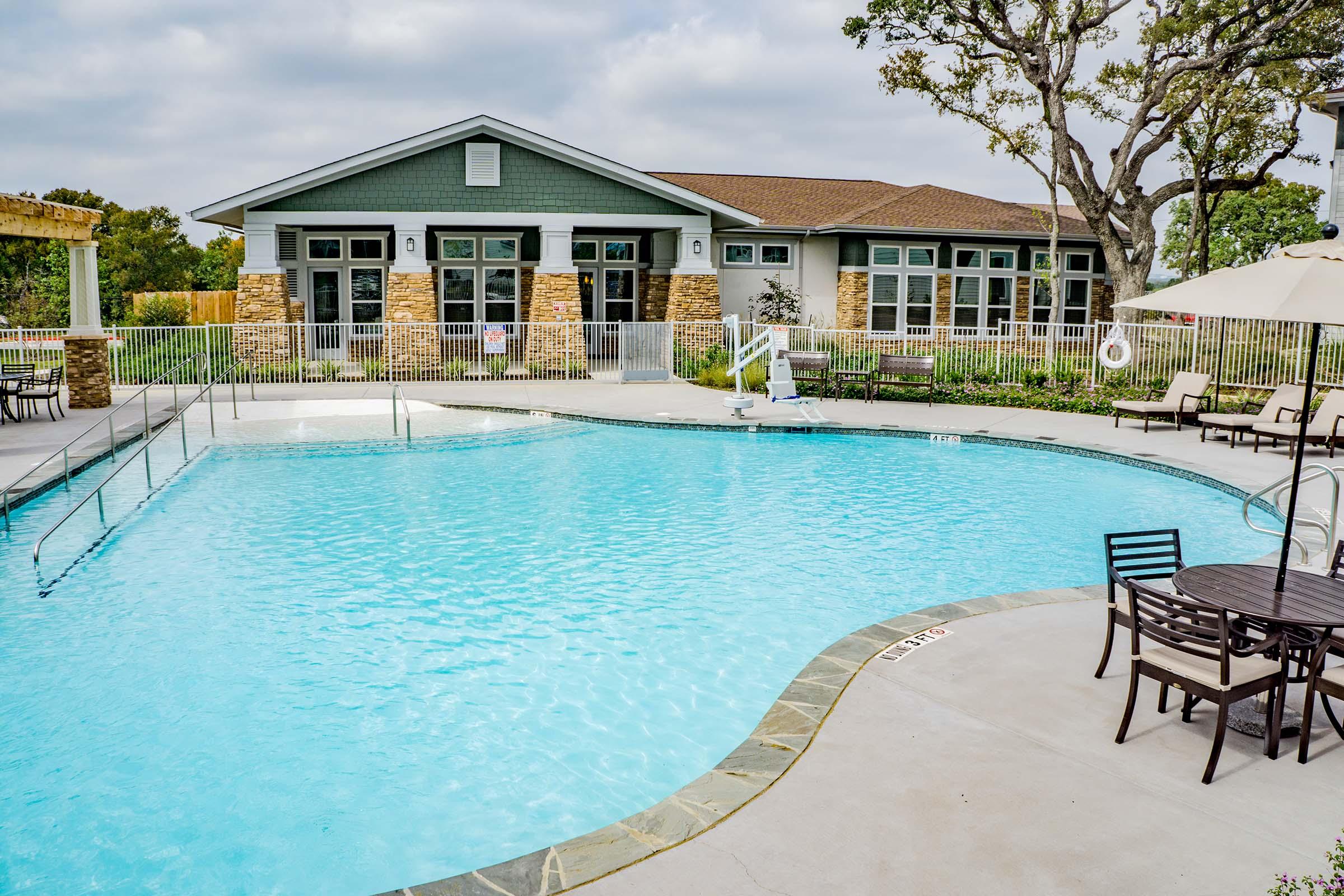 a group of lawn chairs sitting next to a pool of water