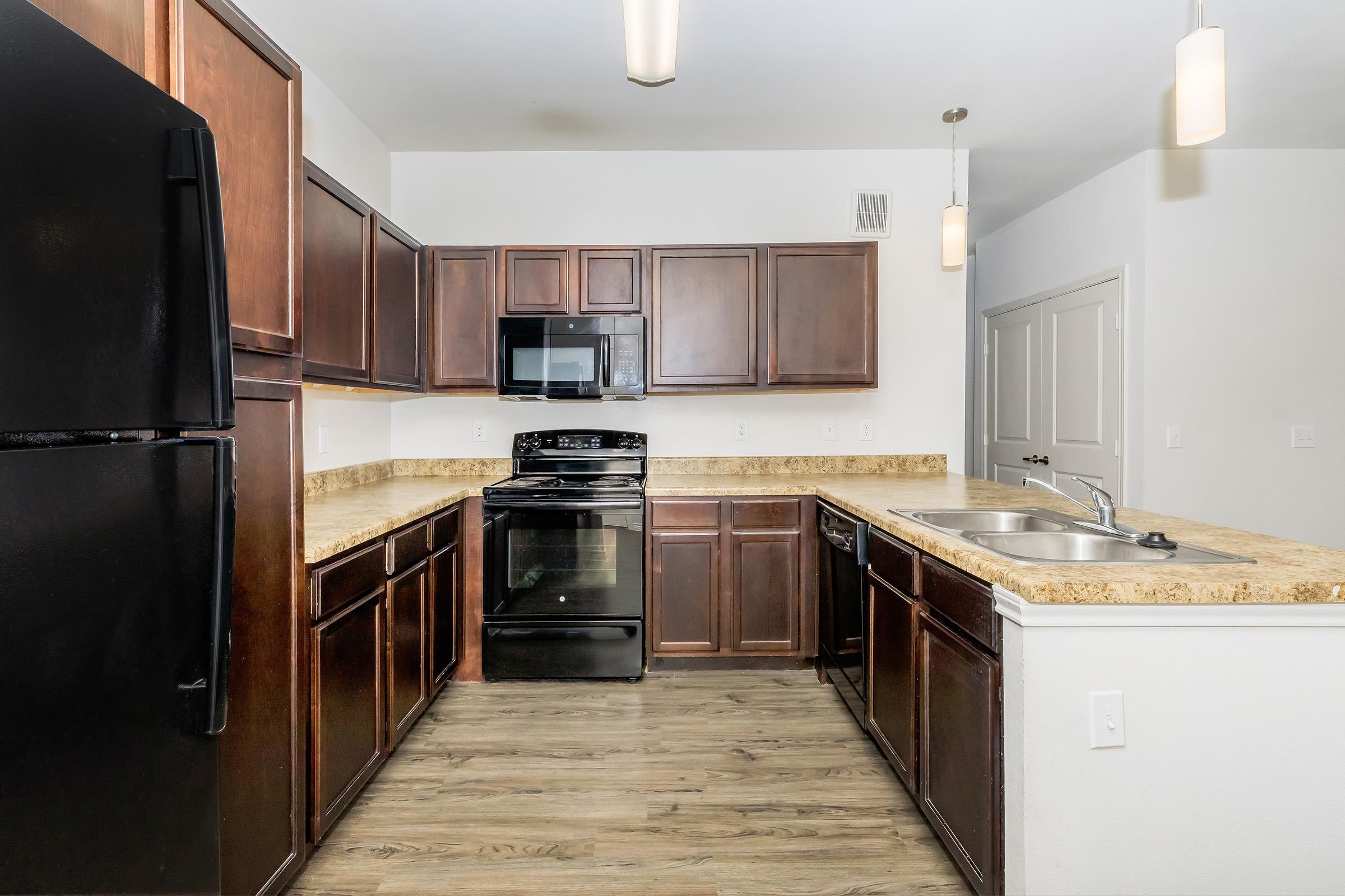 a large kitchen with stainless steel appliances and wooden cabinets