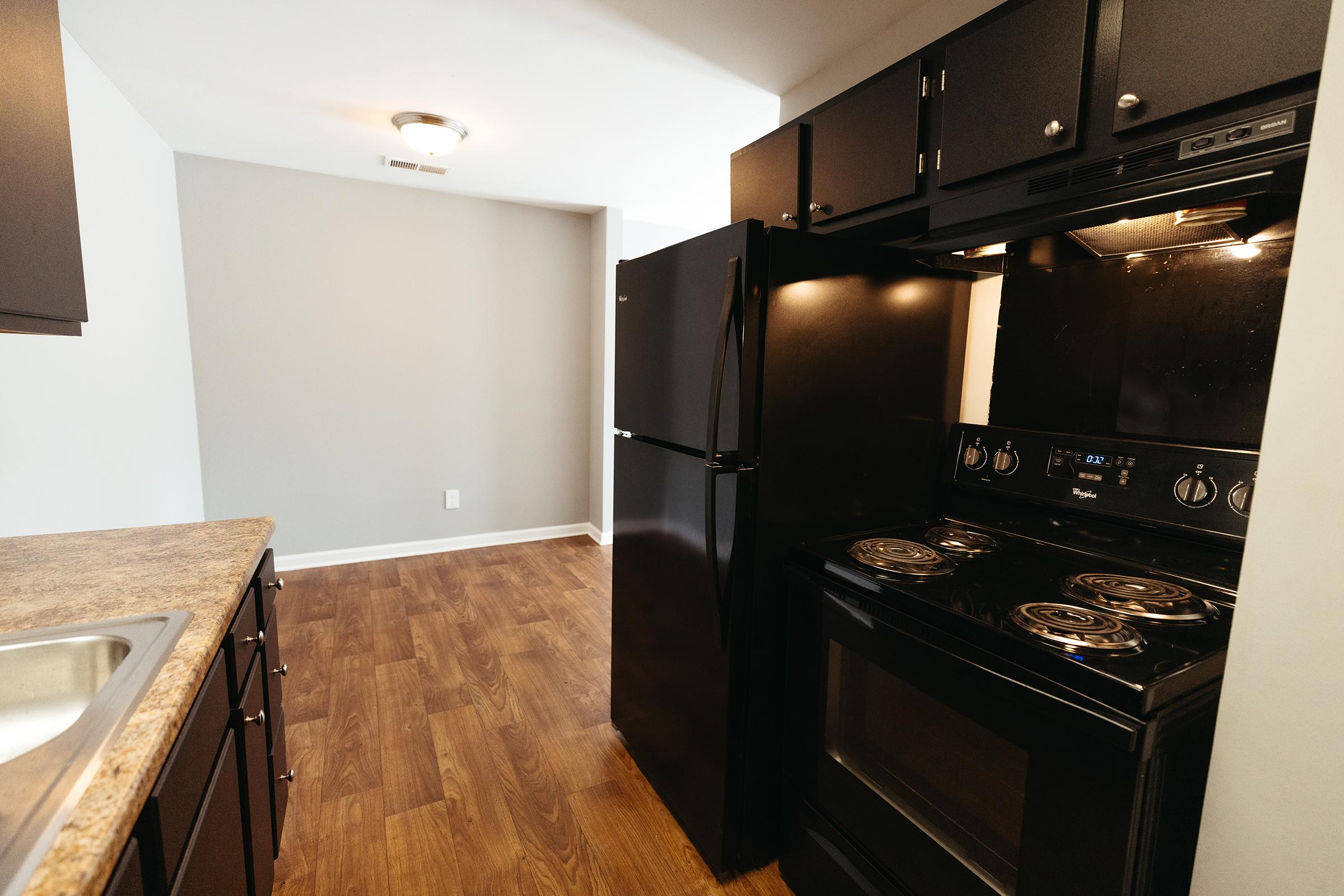 Black kitchen appliances with upper cabinetry.