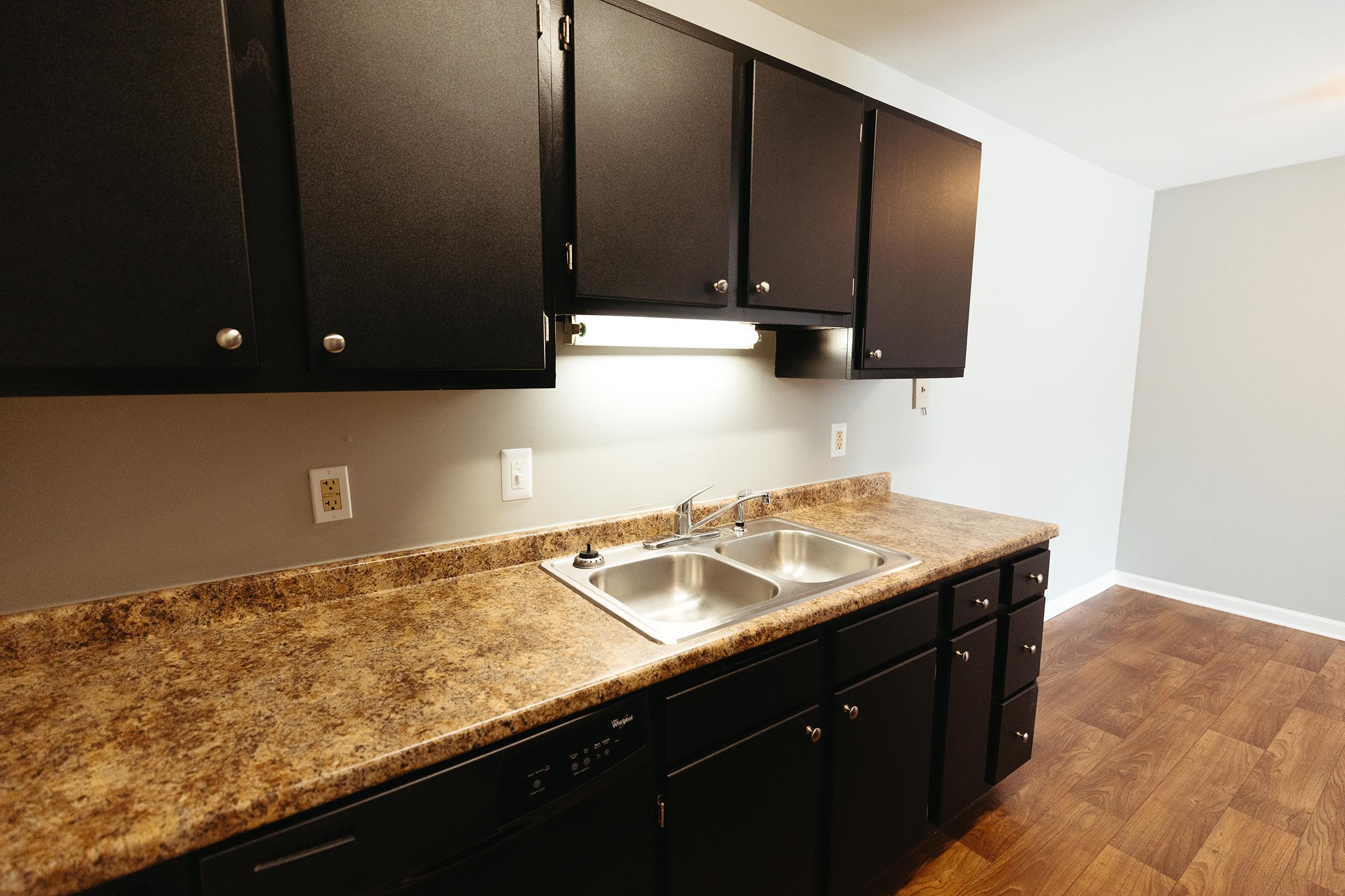 Kitchen counter with cabinetry and sink.