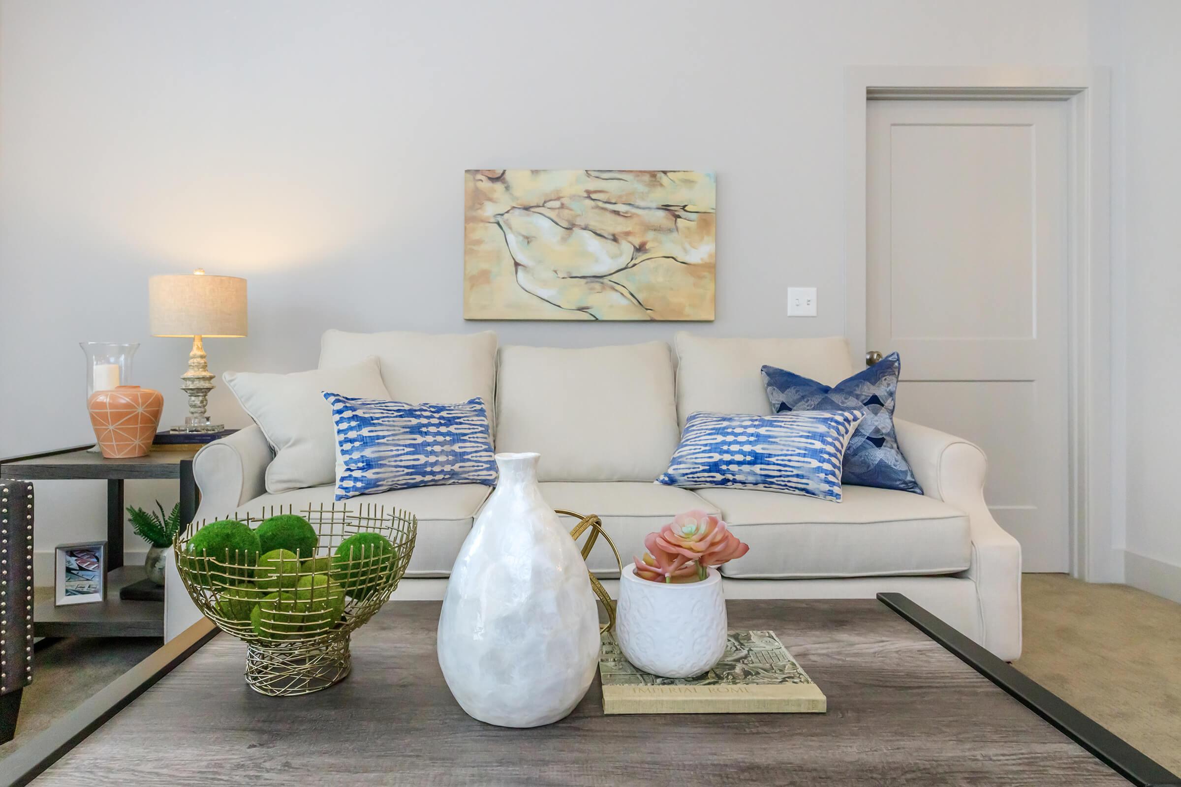 a living room filled with furniture and vase of flowers on a table