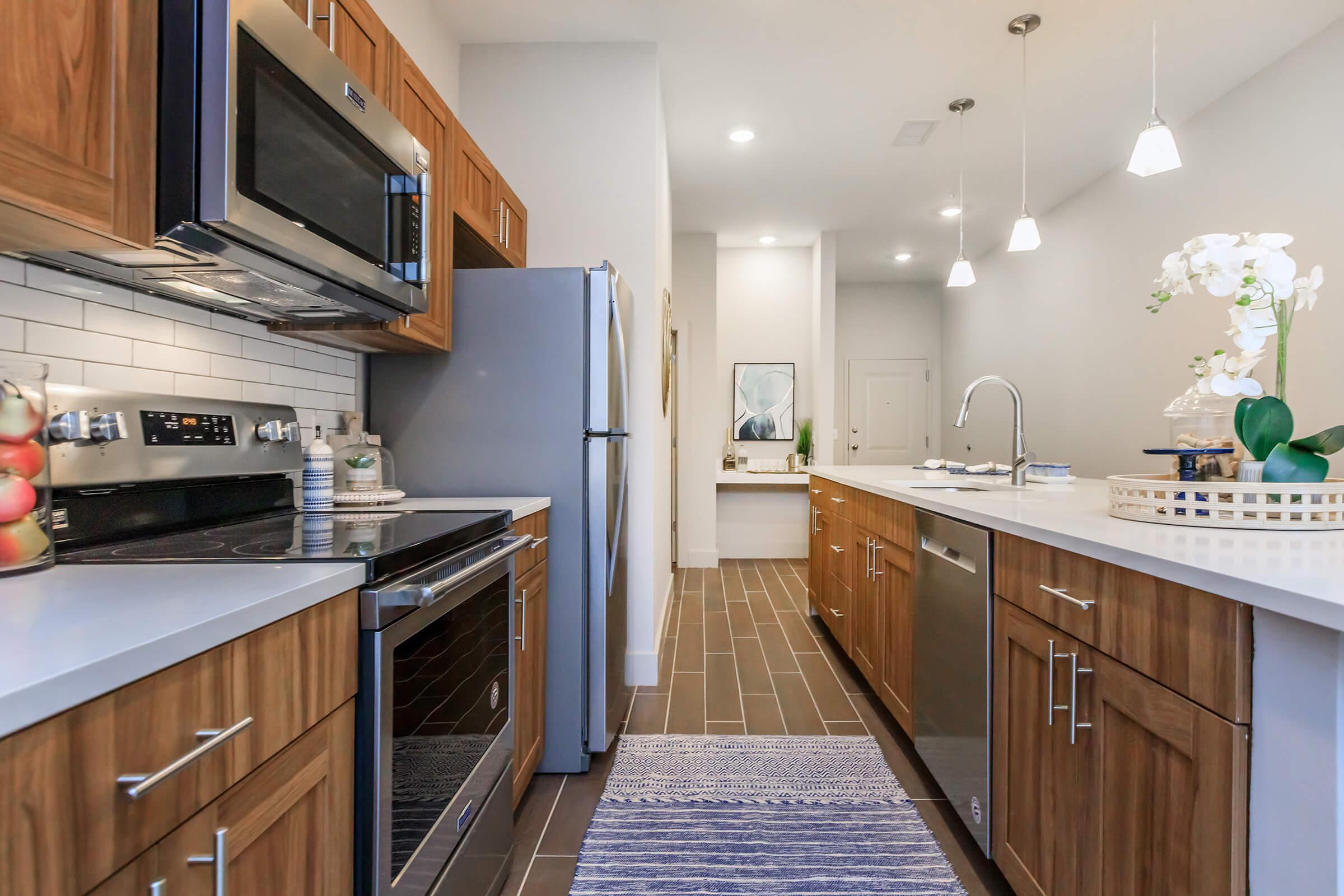 a modern kitchen with stainless steel appliances and wooden cabinets