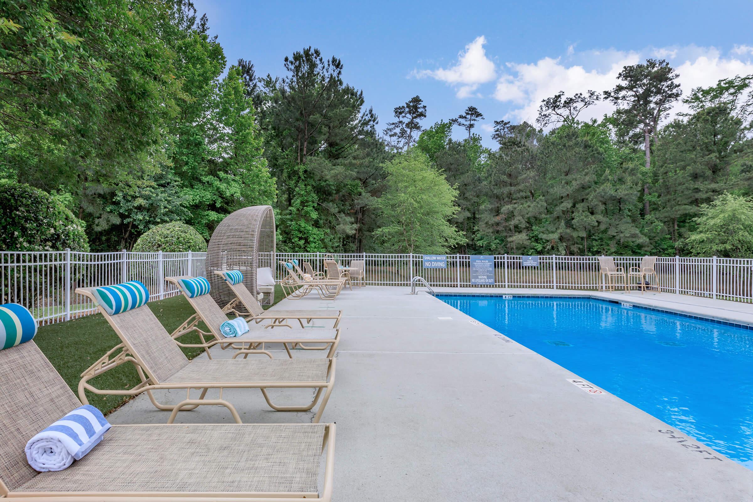 an empty park bench next to a pool of water