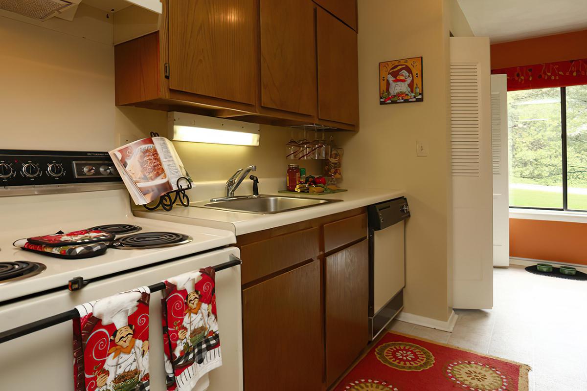 a kitchen with a stove refrigerator and table in a room