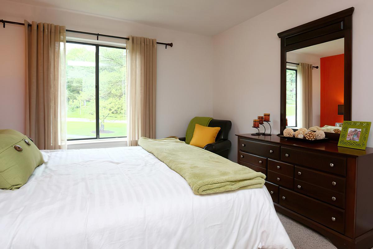 a bedroom with a bed and desk in a hotel room