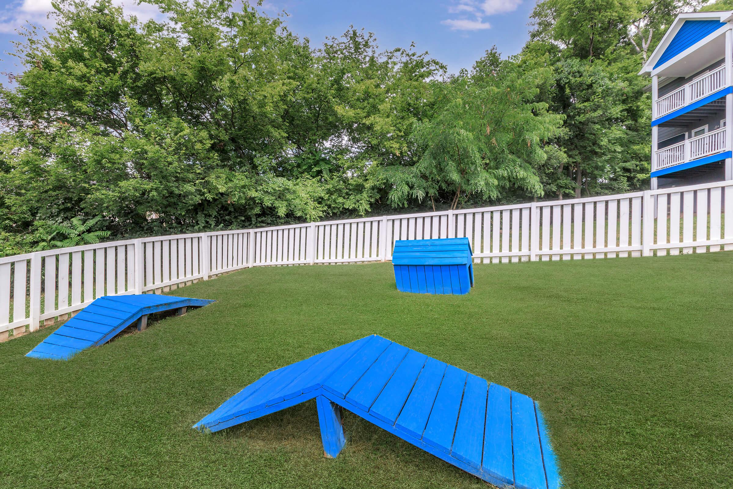 a row of lawn chairs sitting on top of a grass covered field