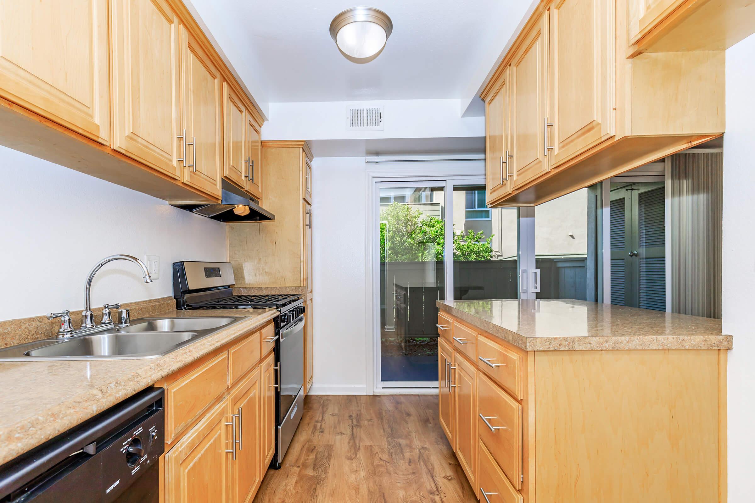 a large kitchen with stainless steel appliances and wooden cabinets