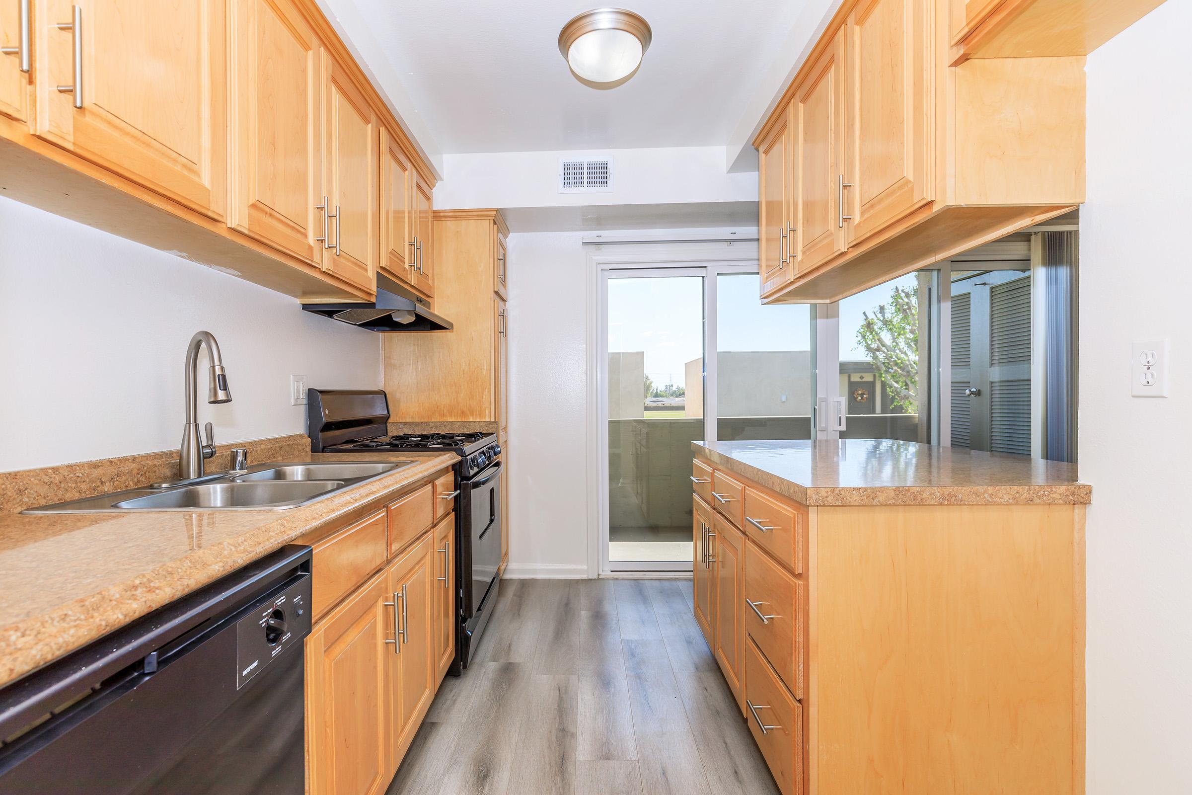 a large kitchen with stainless steel appliances and wooden cabinets