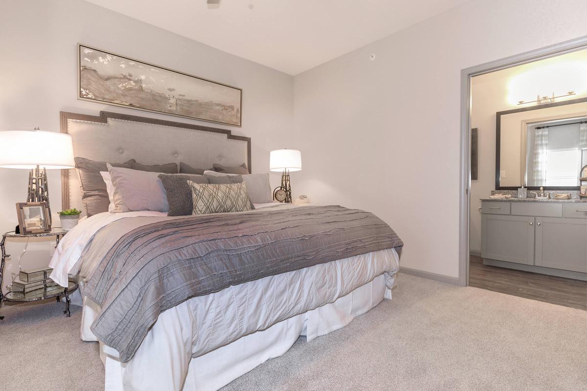 a bedroom with a bed and desk in a hotel room
