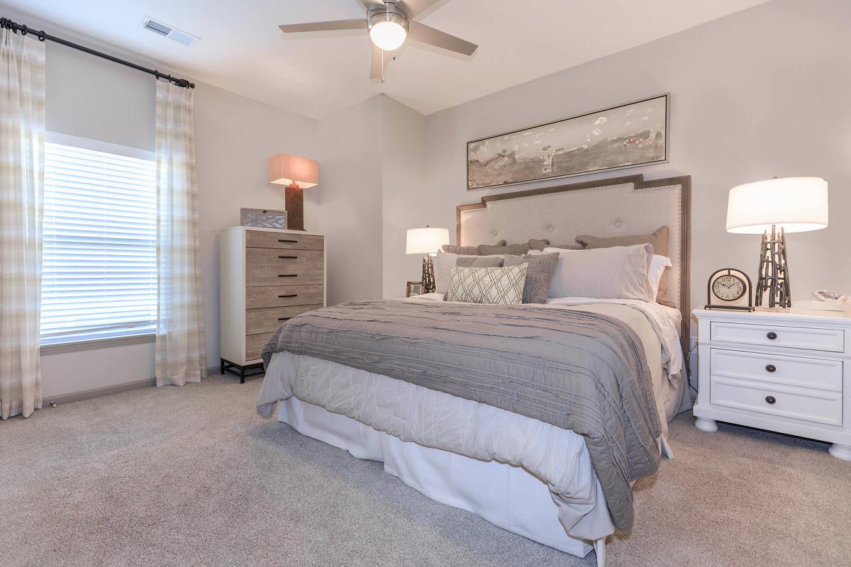 a bedroom with a bed and desk in a hotel room