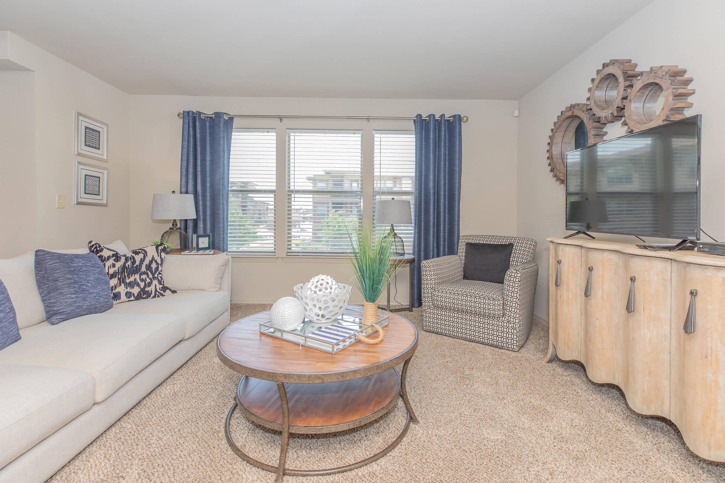 a living room filled with furniture and a large window