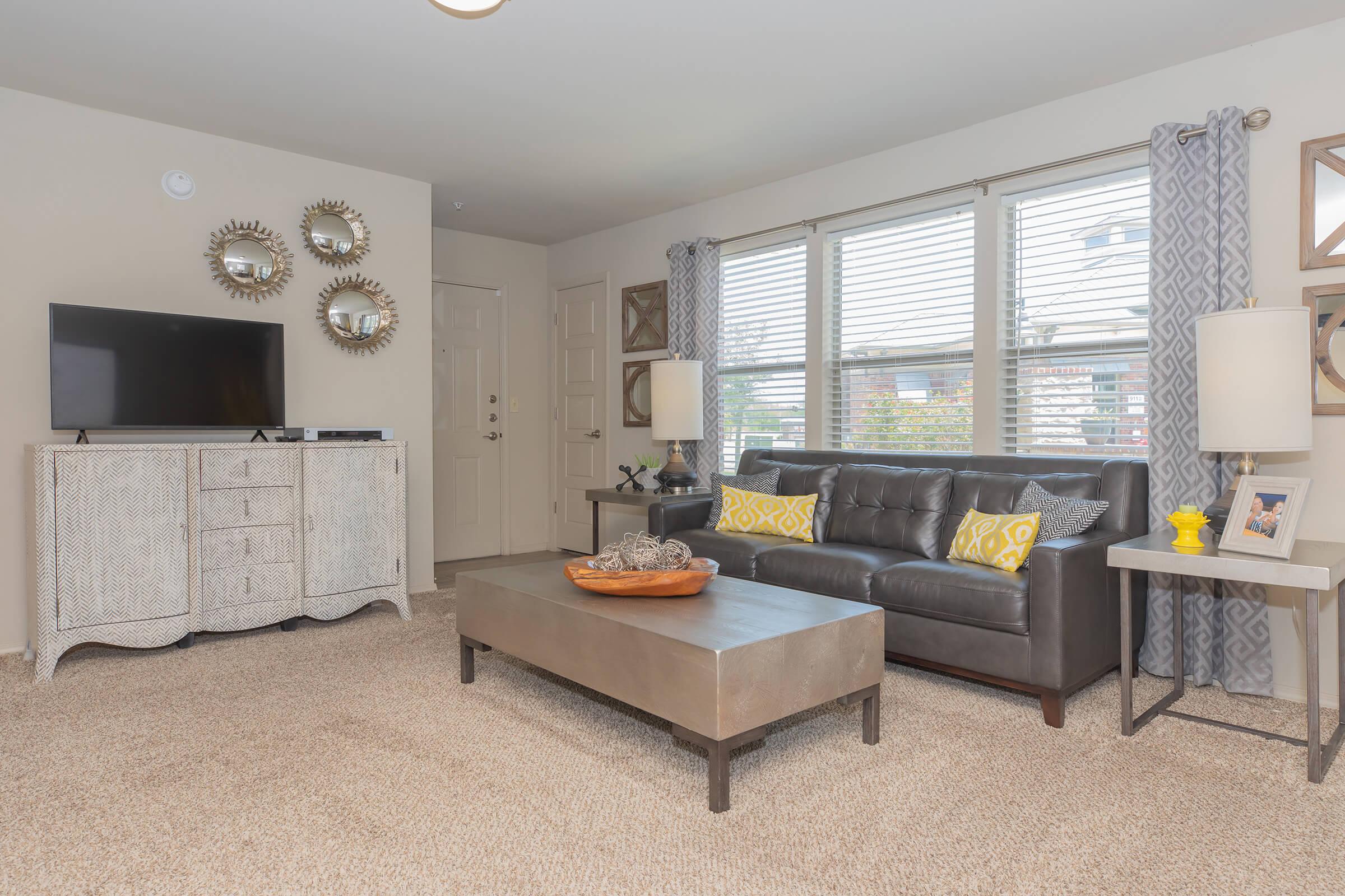 a living room filled with furniture and a large window