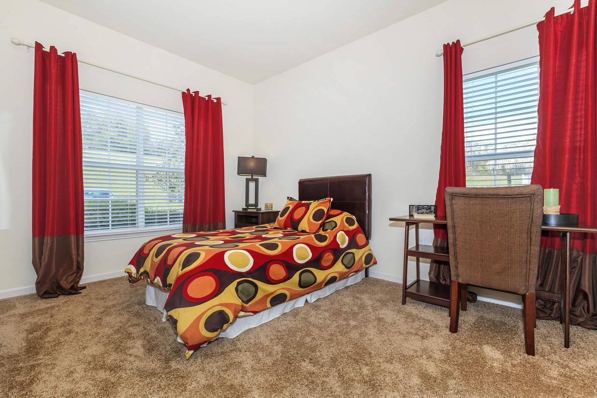 a living room filled with furniture and a red curtain