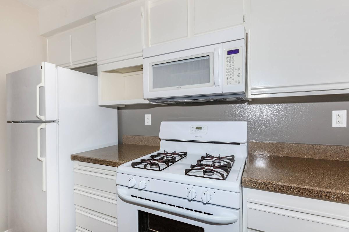 a white stove top oven sitting inside of a kitchen