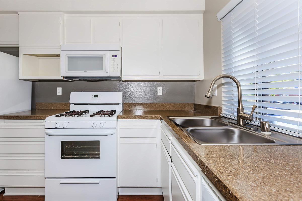 a white stove top oven sitting inside of a kitchen