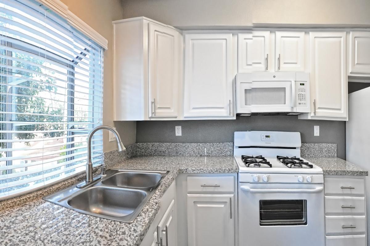 a white stove top oven sitting inside of a kitchen