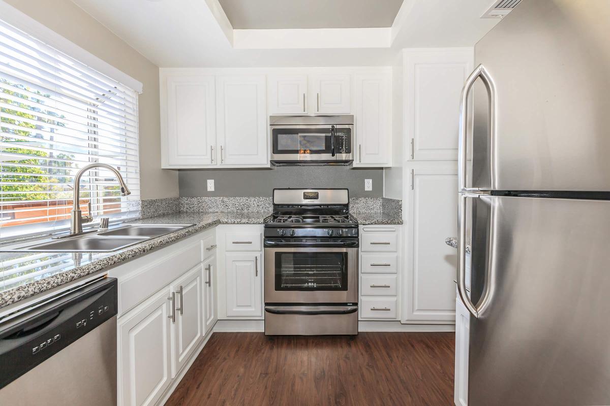 a large kitchen with stainless steel appliances and wooden cabinets