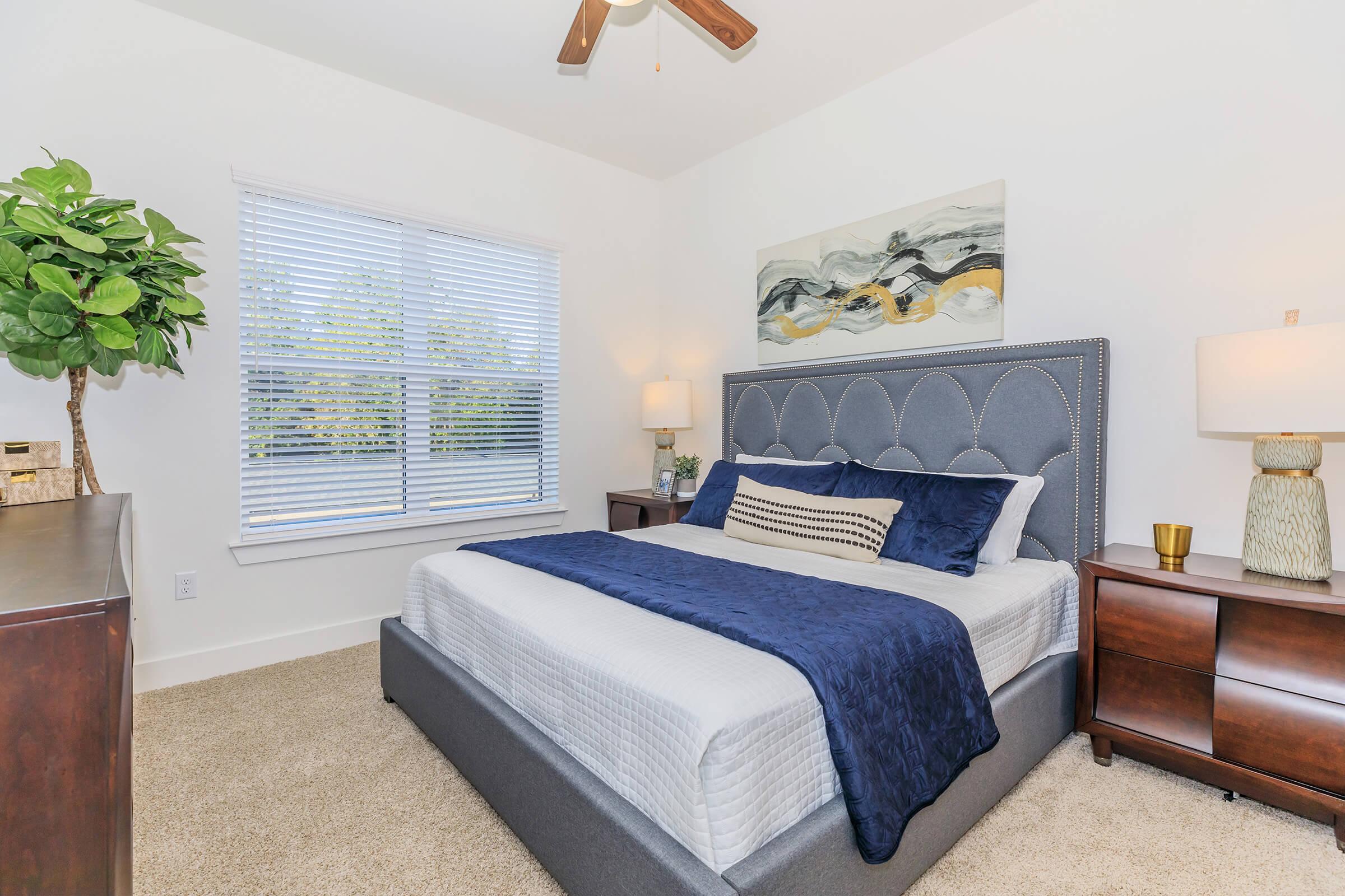 a bedroom with a bed and desk in a room