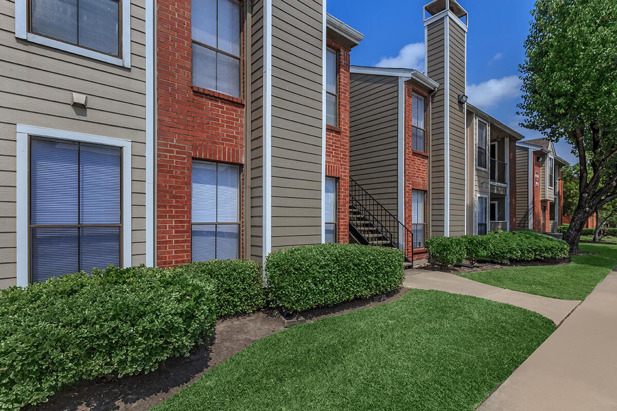 a large lawn in front of a brick building