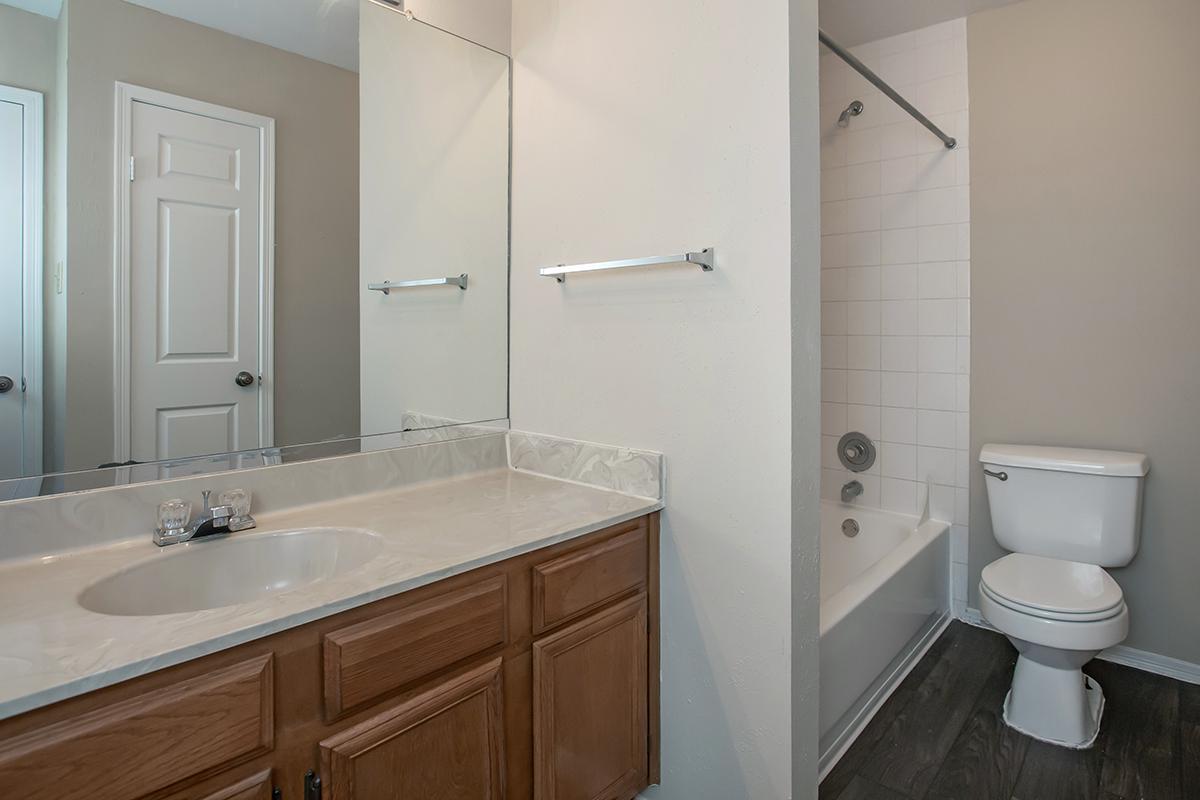 a white sink sitting under a mirror